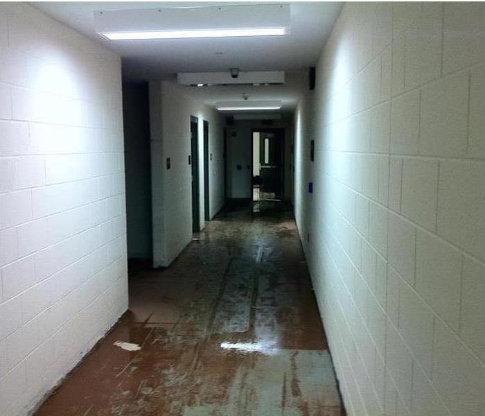 sewage and debris on tiled corridor, block walls and fire doors