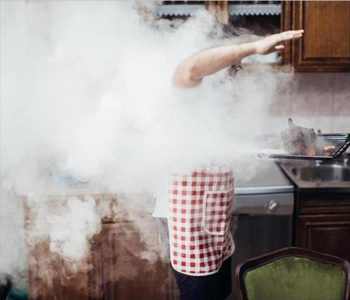 Man inside a kitchen with a lot of smoke